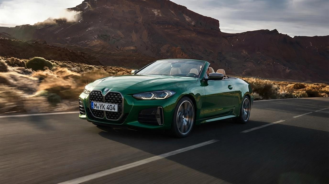 BMW Série 4 Cabriolet vert décapoté sur une route de montagne