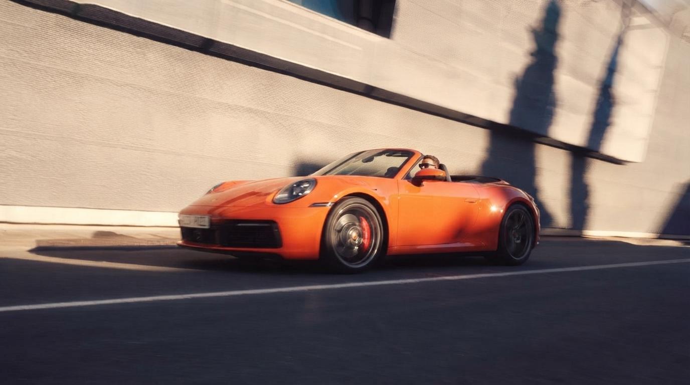 Porsche 911 Carrera cabriolet orange sur une route